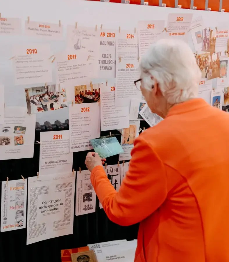 Ältere Frau betrachtet eine historische Zeittafel-Ausstellung