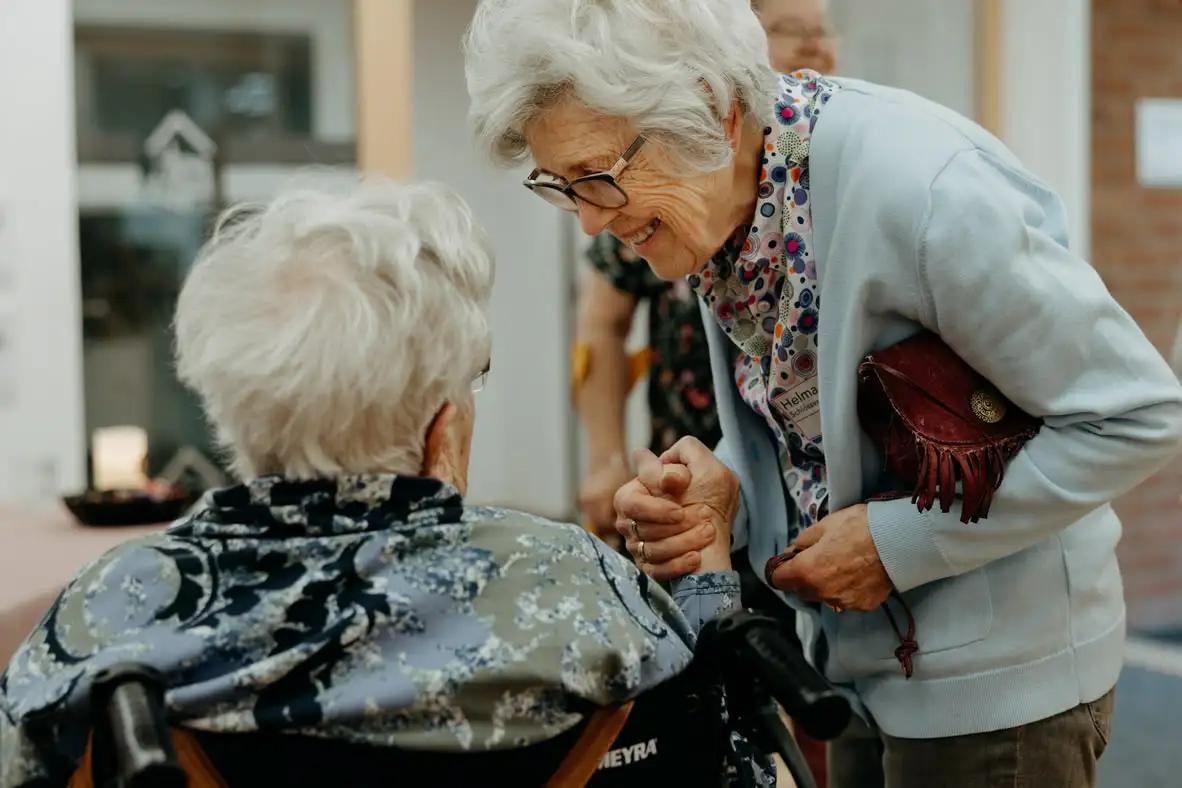 Ältere Frauen unterhalten sich herzlich in einem Innenraum