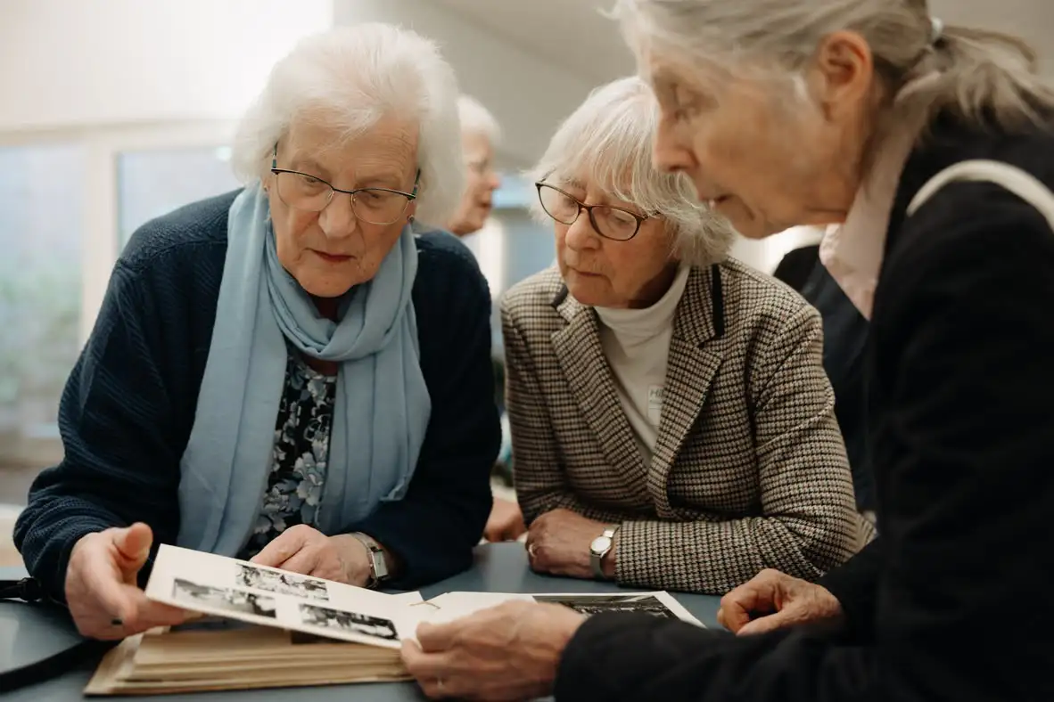 Seniorinnen betrachten gemeinsam ein Fotoalbum